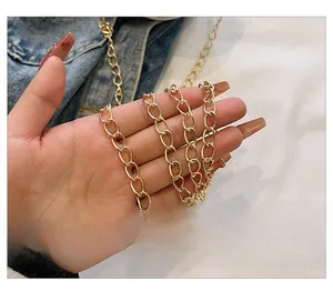 Detail of a shiny gold metal chain strap featuring oval links for a mini shoulder bag
