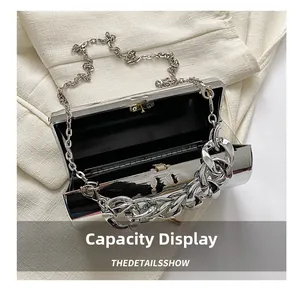 Interior view showing black lining of silver mirror box clutch with thick chain strap