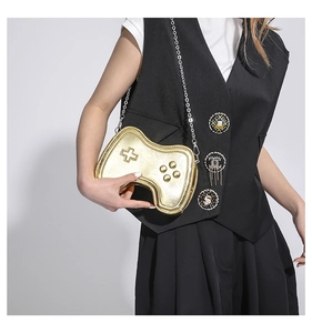 Detail of creative gold game controller crossbody bag with silver chain strap on model