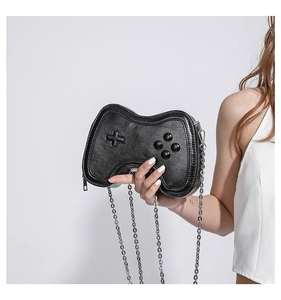 Detail of creative game controller shaped handbag with glossy black leather and silver chain