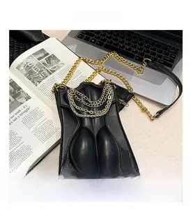 Close-up of artistic 3D female silhouette bag with layered gold and silver chains