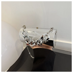 Detail of silver acrylic cylinder clutch bag with chunky metal chain and mirror finish