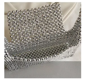 Detail view of the silver beaded handbag showing the woven interior and metallic texture