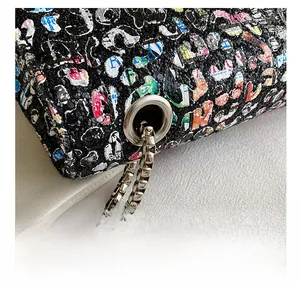 Close-up of graffiti crossbody bag featuring silver chain hardware and sequin texture