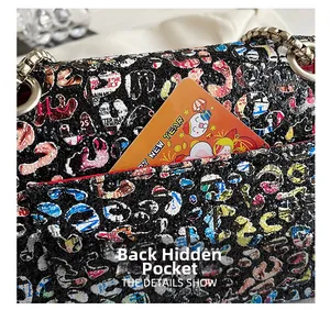 Detail of the back slip pocket on a sequined graffiti crossbody bag with silver chain