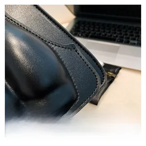 Macro shot of black quilted faux leather handbag detail with glossy finish and fine stitching