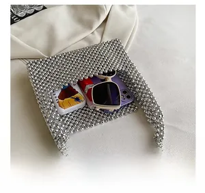 Silver beaded handbag detail showing capacity for phone, lipstick, and sunglasses