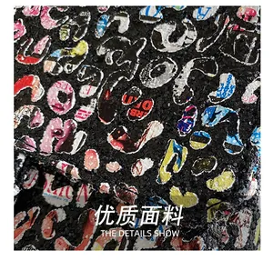 Macro shot of sequin fabric with colorful graffiti and newspaper style letter prints