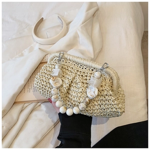 Detail of hand-woven straw handbag with marbled acrylic bead handle and silver buckle