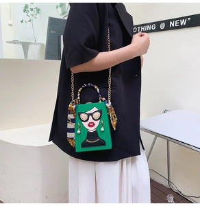Detail of green box bag with pop art female illustration and scarf-wrapped handle