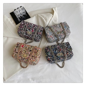 Detail of tweed flap bags with metal chain straps and rectangular twist locks