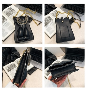 Detail of crossbody bag with 3D body torso design and gold chain strap close-up