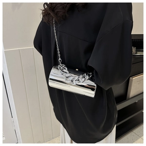 Close-up of a silver acrylic cylinder bag with high-shine mirror finish and thick chain