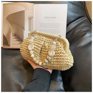 Detail of straw woven clutch featuring chic marble beads handle and vintage metal clasp