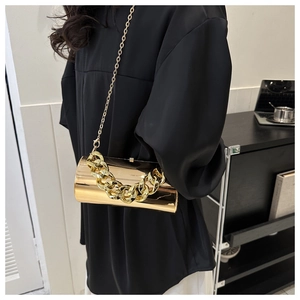 Detail of gold cylinder bag with chunky metal chain and glossy mirror finish