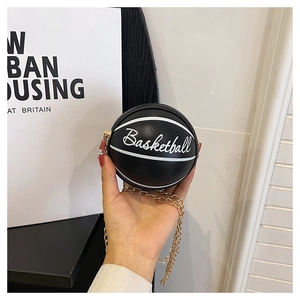 Detail of black basketball-shaped mini PU leather bag with gold chain and white lettering