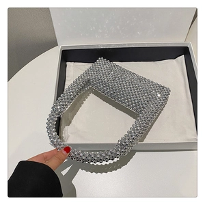 Detailed close-up of handmade silver beaded handbag with metallic beads for formal events