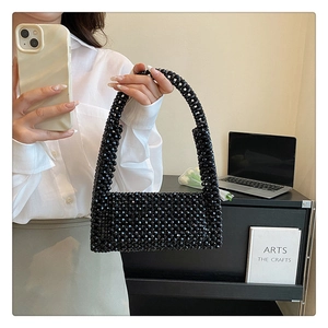 Artistic close-up of a handcrafted black beaded handbag on a minimalist office desk