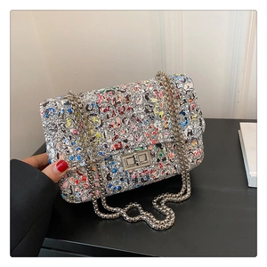 Detail of silver sequin graffiti chain bag with a metallic twist lock and colorful letters