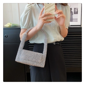 Detail of silver beaded handbag showing metallic texture and handle in mirror selfie