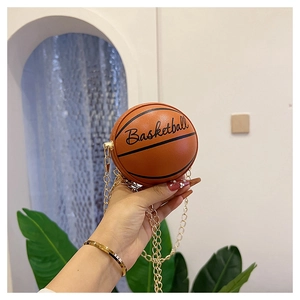Detail of a mini basketball shaped crossbody bag with gold chain strap and brown texture
