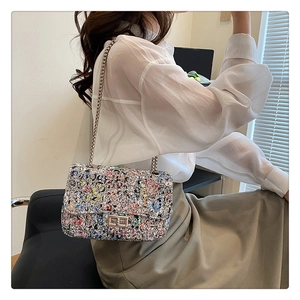 Detail of colorful New York graffiti print and silver twist lock on the crossbody bag