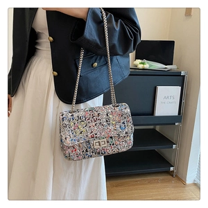 Detail of colorful graffiti crossbody bag with silver chain strap and metal turn lock closure