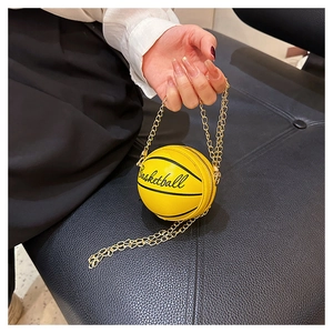 Macro shot of yellow mini basketball-shaped chain bag with realistic texture and gold chain