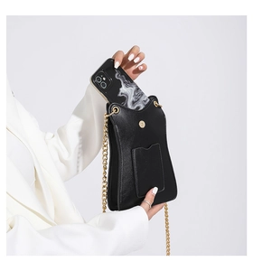 Sac bandoulière minimaliste en cuir noir avec chaîne dorée et détail de téléphone