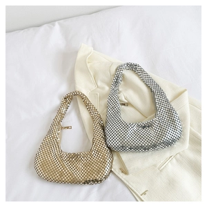 Sacs hobo à paillettes dorées et argentées avec texture maille sur un blazer blanc