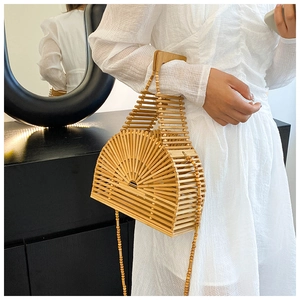 Détail d'un sac à main semi-circulaire en bambou avec poignée en bois porté par un mannequin