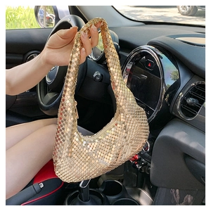Détail d'un sac hobo à paillettes dorées avec texture en maille métallique et fermeture éclair
