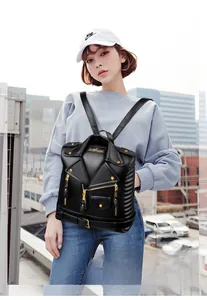 Detail shot of black biker jacket style backpack with metallic zippers and gold hardware