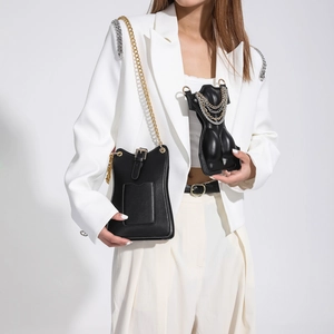 Sac bandoulière créatif en forme de torse noir et sac à chaîne sur costume blanc