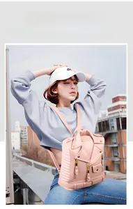 Pink moto jacket style backpack with metal zippers and quilted sides in outdoor setting