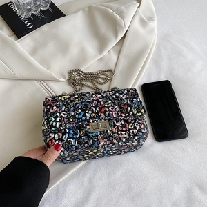 Graffiti leopard print flap crossbody bag with silver chain strap on white blazer