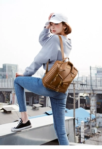 Brown PU leather motorcycle jacket style backpack with zipper details shown on a model