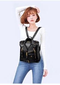 Detail of a biker jacket style backpack featuring gold zippers and rivet accents