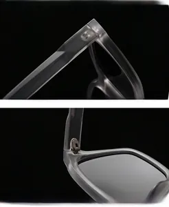 Detail display of translucent grey sunglasses frame with metal hinge and curved temples