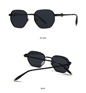 Detail view of black hexagonal sunglasses with golden tips and circular hinge accents