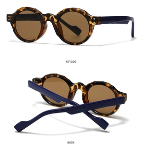 Detail view showing tortoiseshell texture and dark blue temples of retro round sunglasses