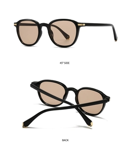 Detail view of vintage black sunglasses with gold hinge accents and tinted brown lenses