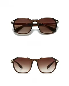 Detail view of tea gradient lenses and brown frame with gold arrow metal accents