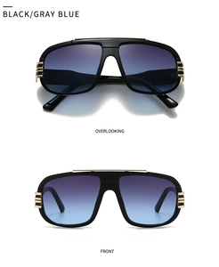 Detail of oversized black pilot sunglasses with gold metal trim and gray blue gradient lenses