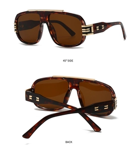 Detail view of tortoiseshell oversized sunglasses featuring gold metal reinforced hinges