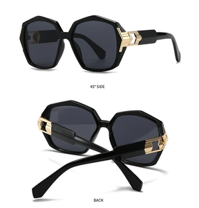 Detail view of modern oversized sunglasses with golden metal hinges and black frame