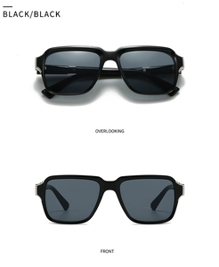 Close-up of black square sunglasses featuring silver metal rivets and glossy finish