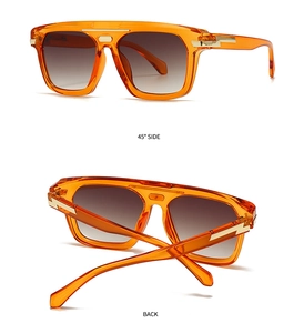 Detail view of orange oversized sunglasses with gold lightning shape temple accents