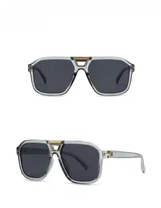 Close-up of modern square sunglasses with grey frames and gold T-shaped hinge detail