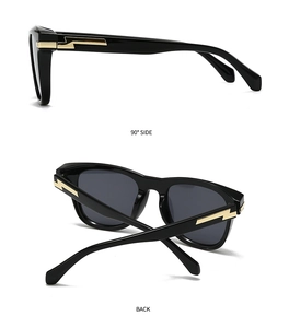 Detailansicht einer schwarzen quadratischen Sonnenbrille mit goldenen Blitzscharnieren